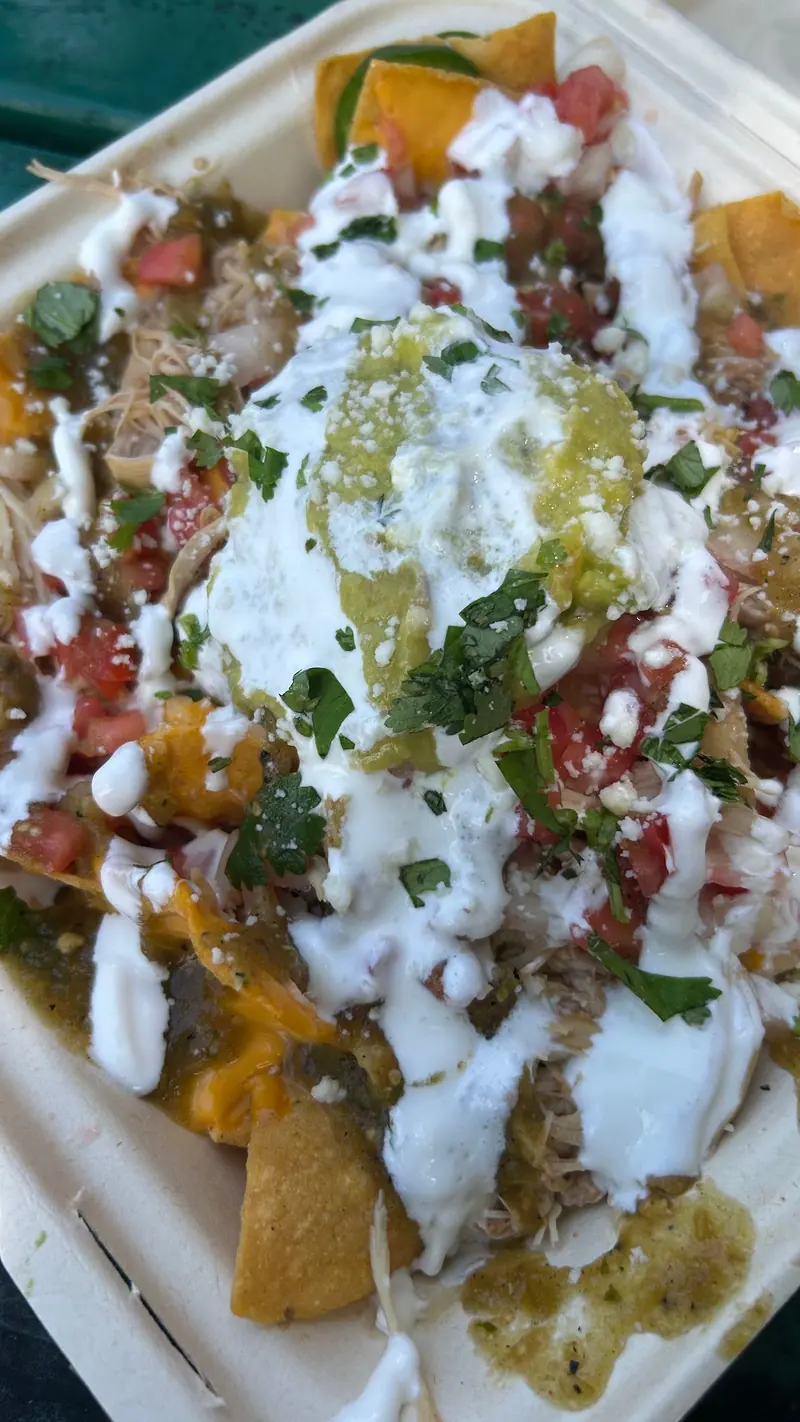 Loaded nachos with sour cream, salsa verde, pico and queso fresco