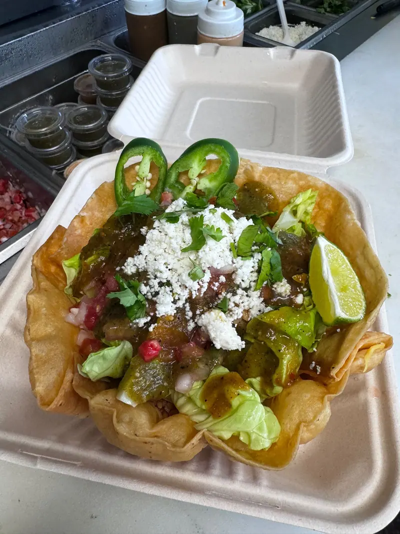 A taco salad bowl in a crispy flour shell with lettuce, pico, salsa verde, queso fresco, jalapeño and lime, at the Ae’s Sassy Tacos truck in Hāna